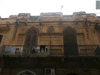 Foto 13. Questo �buco� si trova accanto a un basso edificio fatiscente, di colore ocra, che per� conserva ancora un particolare rilievo: spicca centrale la figura di un bambino, circondato da alcune foglie di quello che sembra alloro. Il tutto � sovrastato da una singolare cornice merlata